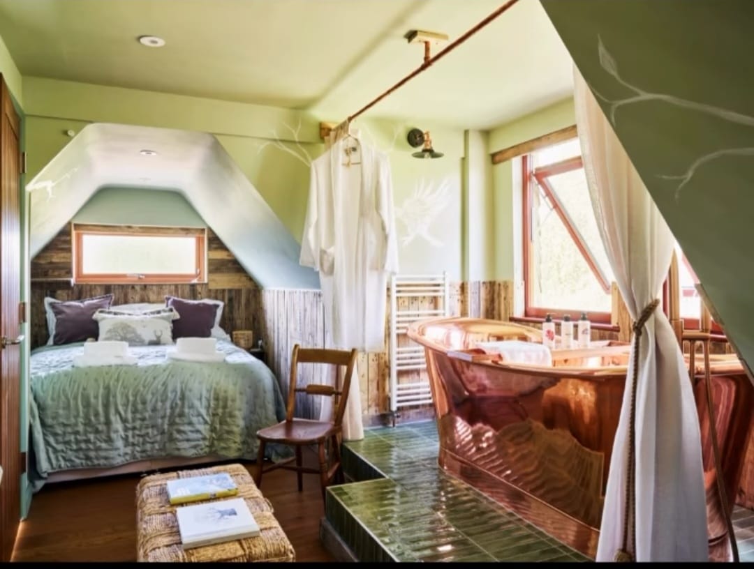 A cozy bedroom with a large bed and copper tub